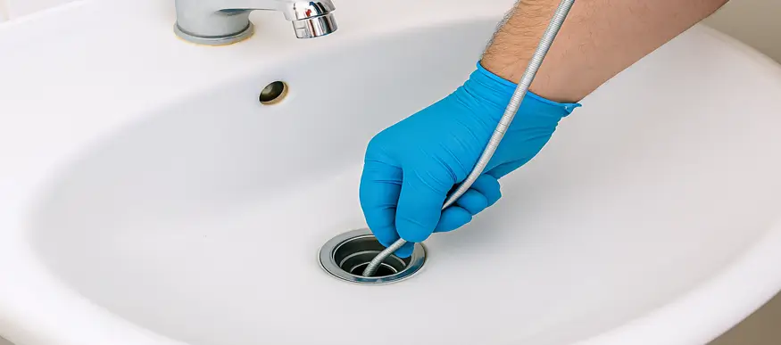 Plumber cleaning drain in The Woodlands